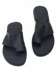 Theluto Mykonos black leather slip-on sandals with a toe loop design, featuring a comfortable reinforced sole.