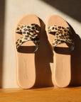 Theluto Prune Cheetah slip-on sandals featuring a tan leather sole and a crisscross strap with animal print texture.