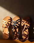 Theluto Valentine leather sandals in tan and black, featuring a slip-on design with crisscross straps and buckles.