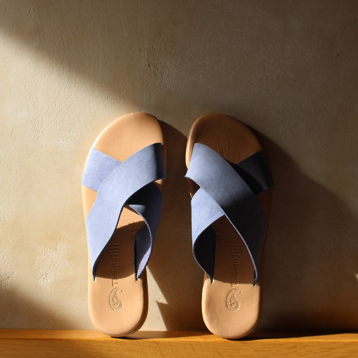 Theluto Gaelle blue leather slip-on sandals with a crisscross strap design and cushioned tan footbed