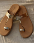 Theluto Héloïse handmade gold leather toe-ring sandals with natural tan soles, crafted in Greece.