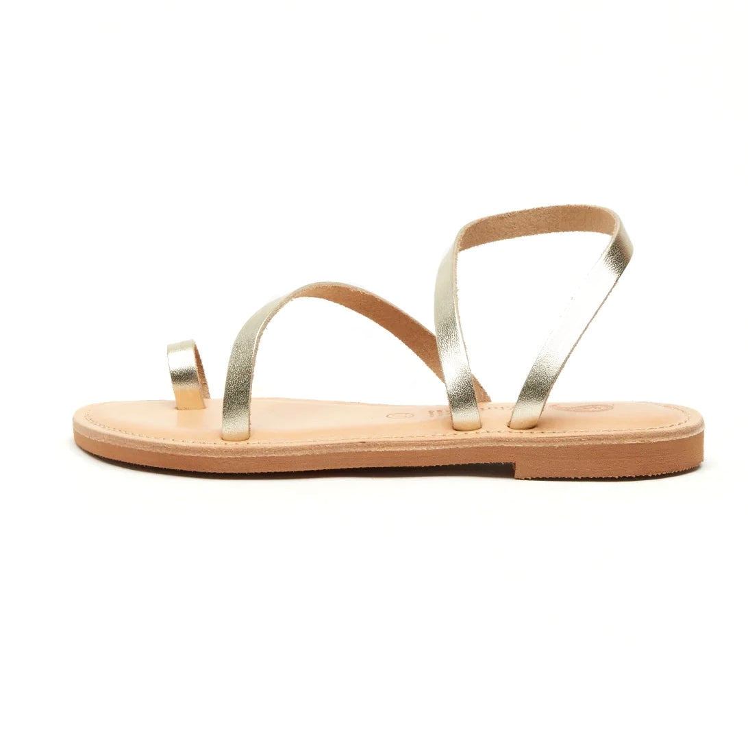 Theluto Lilou handcrafted gold leather sandals with a minimalist toe-ring design and flat sole, side view.