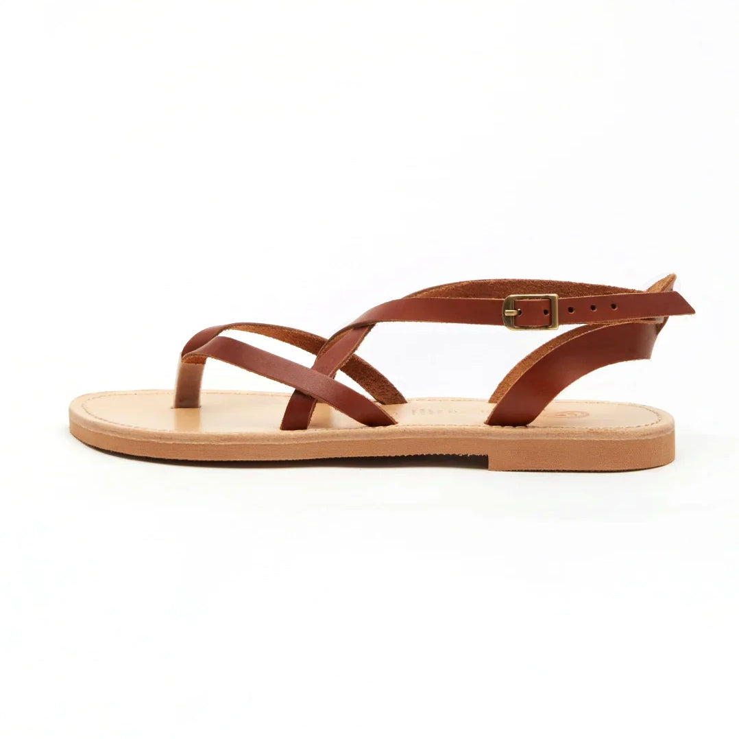 Theluto Marie brown leather flat sandals with minimalist crisscross straps and an adjustable ankle buckle