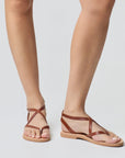 Theluto Marie brown leather minimalist sandals worn on feet, featuring a comfortable flat sole and strappy design.