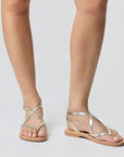 Theluto Marie minimalist gold leather sandals with a comfortable flat sole and elegant crisscross strap design.
