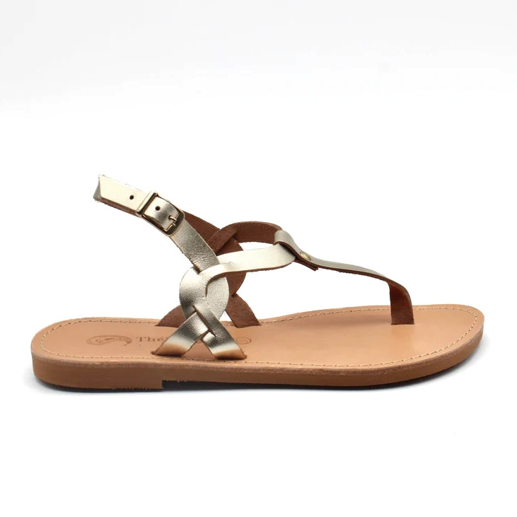 Theluto Meloe gold leather thong sandal with braided straps and an adjustable ankle buckle on a flat leather sole