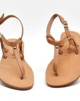 Theluto Meloe tan leather thong sandals with ankle straps and a minimalist design on a white background.